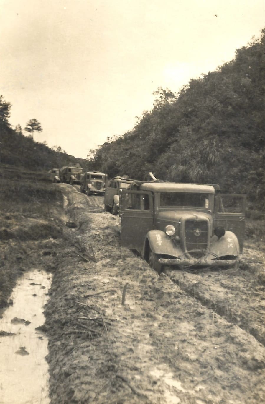 Column of Japanese Type 97 Isuzu trucks.jpg